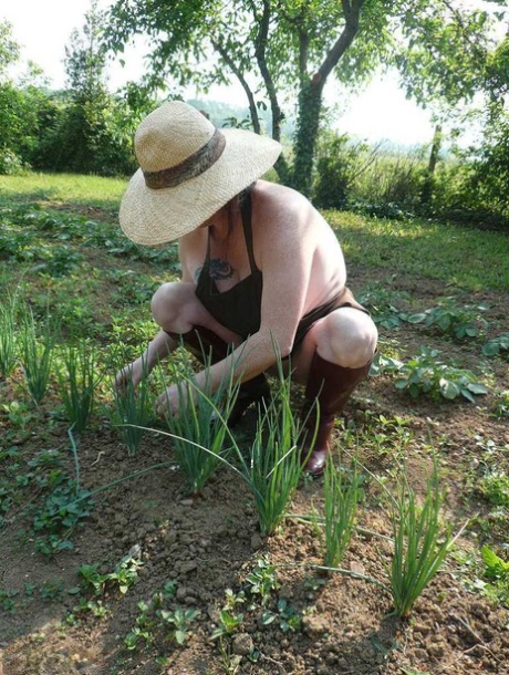 Mature lady Mary Bitch tends to her garden while naked in sunhat and apron 86145897