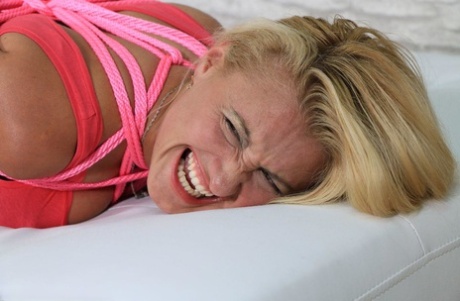 Fully clothed blonde grimaces while hog tied with pink rope in black stockings 58466926