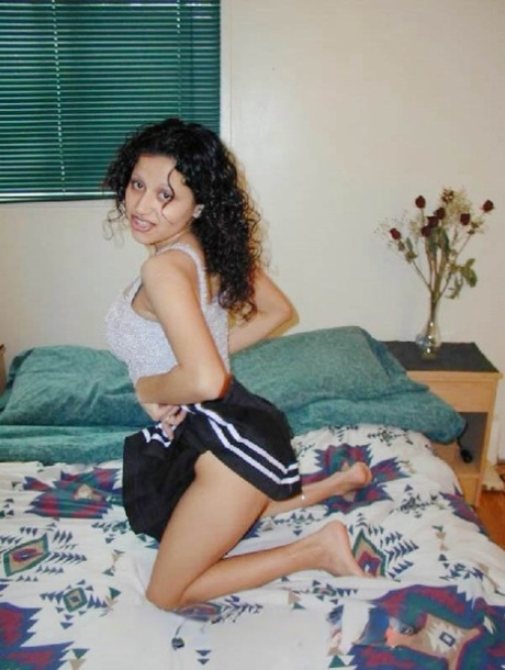 Cute Latina girl uncovers her natural tits while kneeling upon a bed 55828527