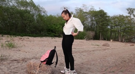 Solo girl Pinkycat pauses to piss upon a boulder while walking a beach 16295167